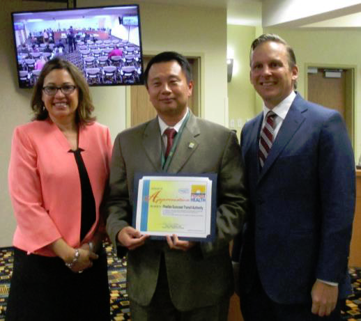 The certificate was presented By Dr. Ulyee Choe (center) to Darden Rice, PSTA’s Chair, and Brad Miller, its CEO.