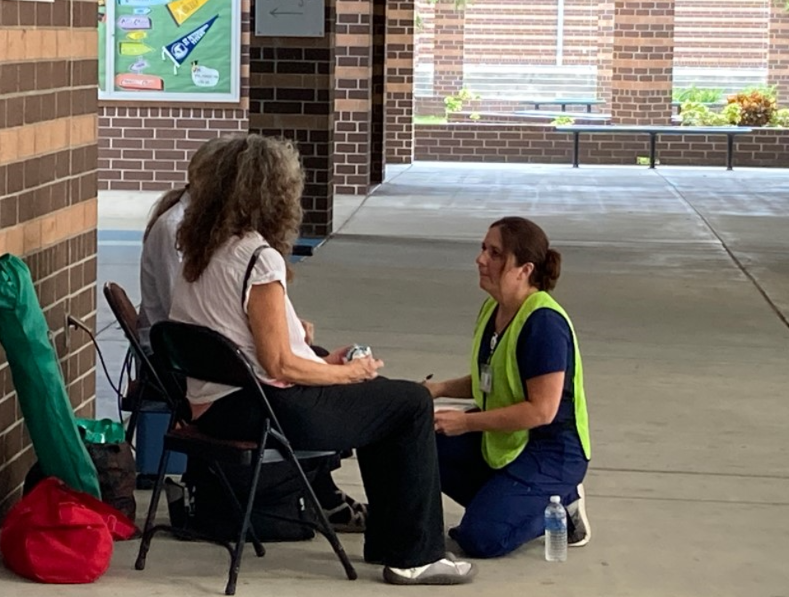 DOH employee providing medical care in public space.