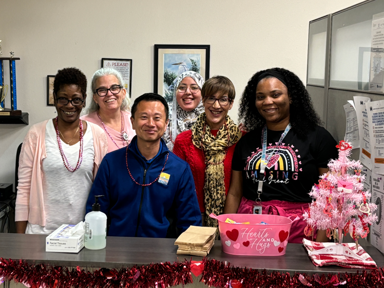 DOH Employees celebrating valentines day at desk with valentines themed decorations.