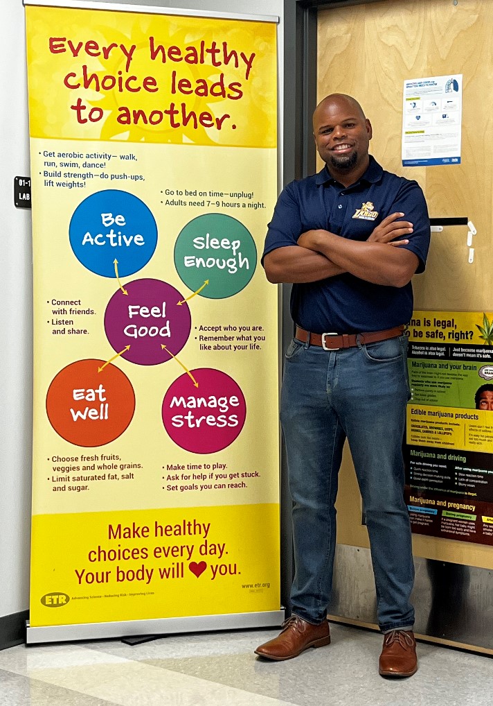 Image of a health educator in front of banner that heads: every healthy choice leads to another.