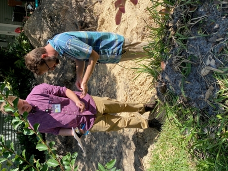 2 gentleman looking at soil in their hands