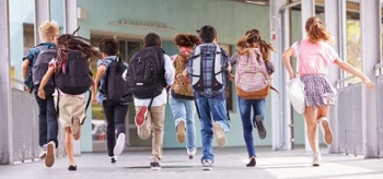 kids running away from camera with backpacks